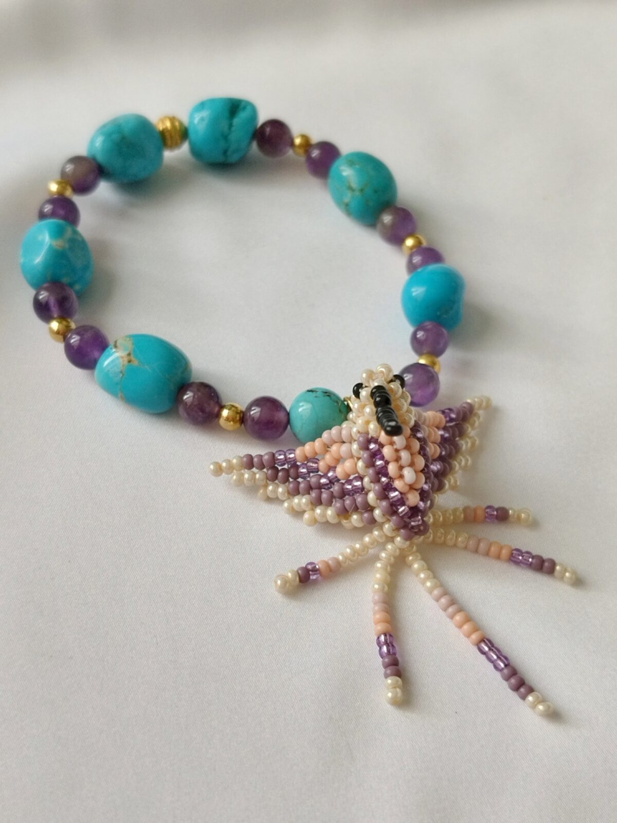 Pulsera en Piedras naturales de Turquesas y Amatistas con Dije de Colibrí tejido a mano por indígenas del Putumayo.