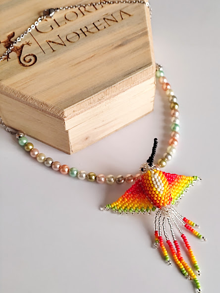 Gargantilla en Perlas Shell pastel - con Dije de Colibrí tejido a mano por indígenas del Putumayo.