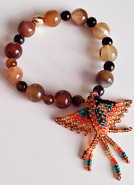 Pulsera en Piedras naturales de Ágatas lisas con Dije de Colibrí tejido a mano por indígenas del Putumayo.